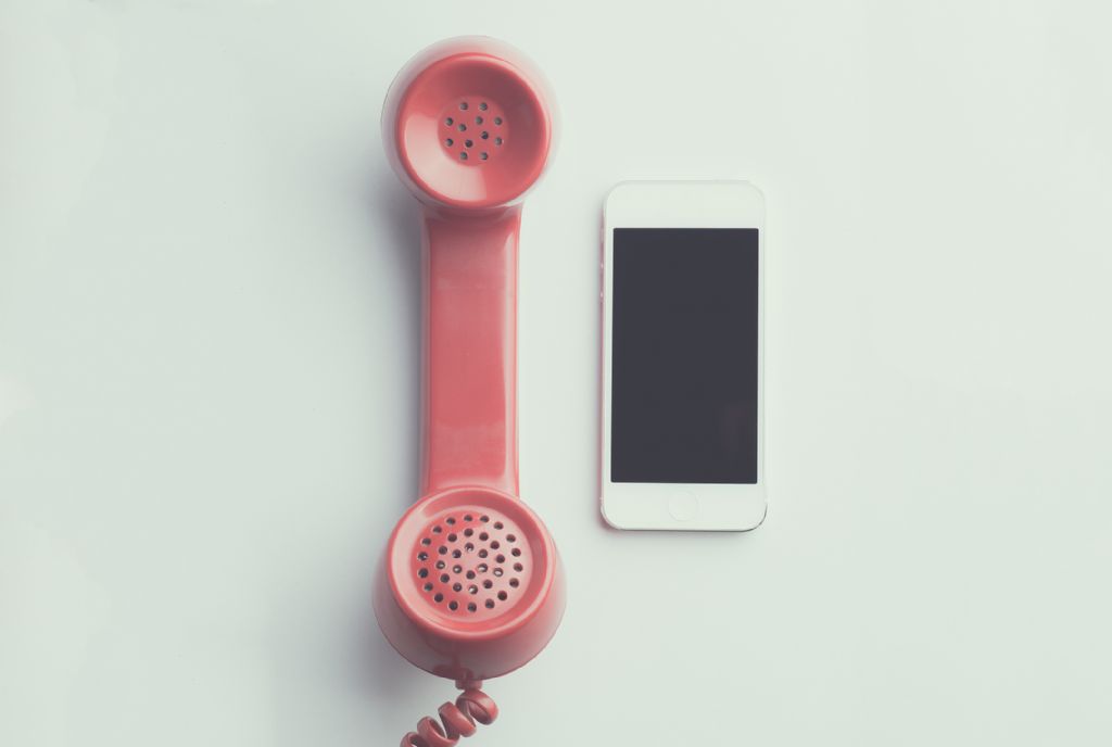 canva - flat lay photography of red anti-radiation handset telephone beside iphone